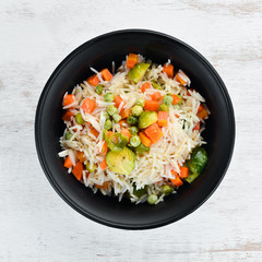 Risotto with vegetables in a plate. Rice. On the old background. Top view. Free space for your text.