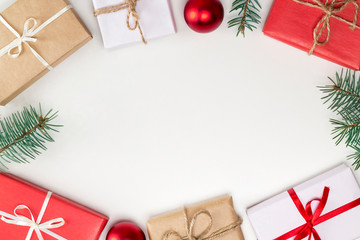 Frame from Christmas gifts, red balls, fir branches on white background. Greeting card, New Year concept. Copy space, top view, flat lay, layout design