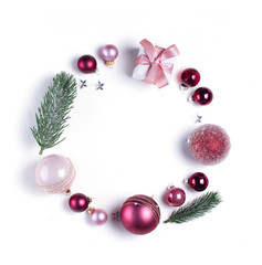 Fototapeta na wymiar Christmas flat lay round frame with pink glass balls and gift box, copy space over white desk
