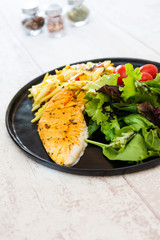 close-up of plate of pasta and chicken with lettuce