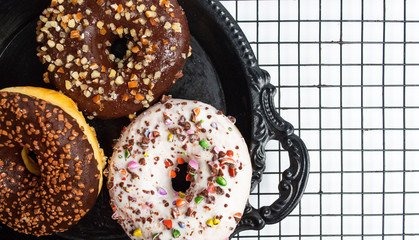 Decorated chocolate donuts on a baking grid