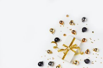 Christmas flat lay top view scene with golden, gray and black glass balls and gift box with golden bow