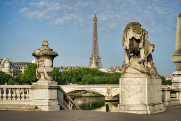 Fototapeta na wymiar PARIS, FRANCE - MAY 26, 2018: Sculpture of a lion on Pont Alexandre III. View of the bridge of the Invalides and the Eiffel Tower.