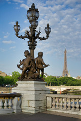 Fototapeta na wymiar PARIS, FRANCE - MAY 26, 2018: Sculptures on Pont Alexandre III. View of the Bridge of Invalids and the Eiffel Tower.