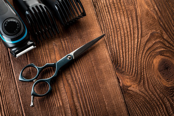 Hair trimmer and scissors on the wooden background. Beard and hair clippers.