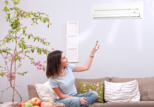 woman using remote control   of  aircondition  