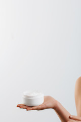 Closeup shot of woman hands holding cream and applying moisturizing hand cream. Beautiful female hands with cream. Hand Skin Care. A woman uses body lotion on your arms. Beauty And Body Care Concept