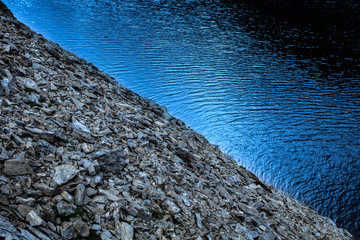 Wall of rocks sliding towards the water