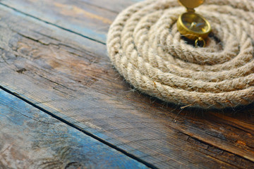 Nautical navigation background. Sea rope with a compass on a wooden desk. Copy space.