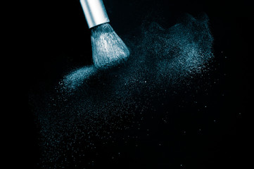 Deep ocean powder color splash and silver brush for makeup artist or beauty blogger in black background, look like a look like a cold and calm mood.