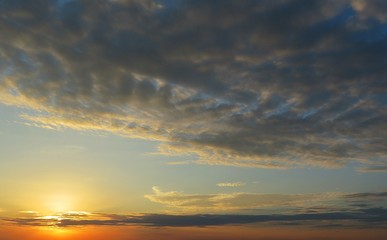 Beautiful yellow sunset background with dark clouds 