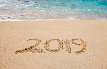 Fototapeta na wymiar 2019 written on white sandy beach of the Caribbean. Tropical New Year background