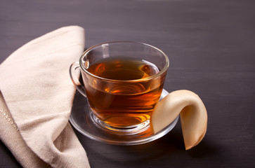 Cup of tea with fortune cookie on a wooden background