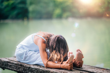 Yoga Woman by The Lake. Seated Forward Bend