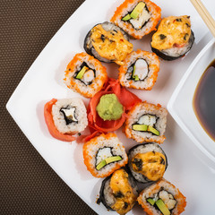 Top view on a dish of various sushi in a white plate