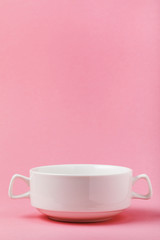 White ceramic soup mug on a pink background with the copy space