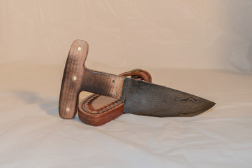 A Damascus push knife, also known as a T knife with custom fit leather sheath.