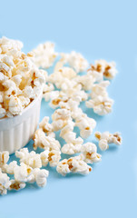 Popcorn on a bright blue background. Film. Fast food. Corn