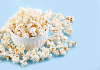 Popcorn on a bright blue background. Film. Fast food. Corn