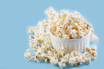 Popcorn on a bright blue background. Film. Fast food. Corn