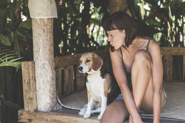 Close up portrait of young woman with her cute beagle dog in gazebo.
