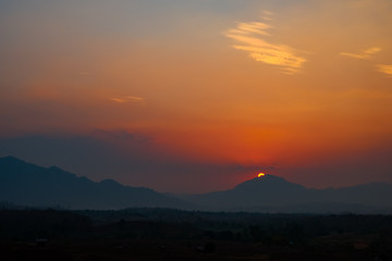 Beautiful sunset with mountains covered with orange horizon.