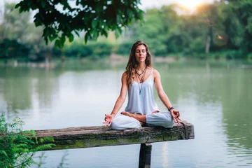 Fotobehang Woman Meditating by the Lake © Microgen