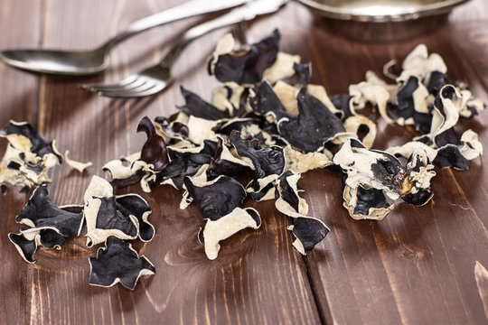 Lot of slices of dry black mushroom jew ear variety on brown wood