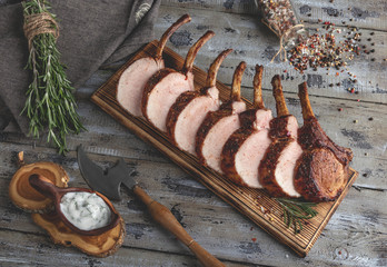 Grilled roasted rack of pork,slice meat chops  bone on a portion wooden board