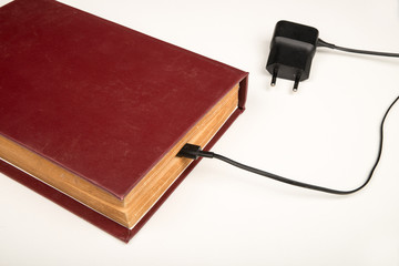 Old book with a battery charging cable © Olaf Speier