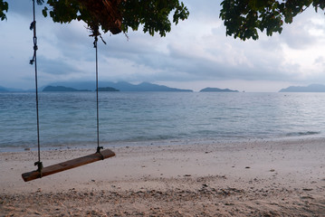 Wooden swing hanging from a tree on the beach in the morning , Kohwai island, Trad province, Thailand.