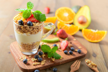Granola and yogurt and fruits on topping in glass