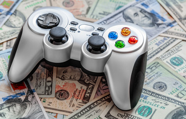 Silver wireless gamepad on dollar bills background