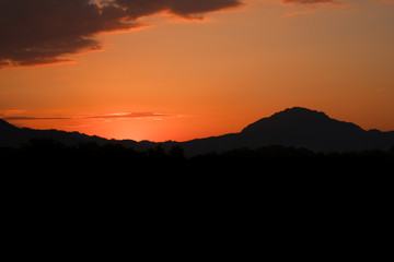 Beautiful sunset with mountains covered with orange horizon in Mae Sot, Thailand.