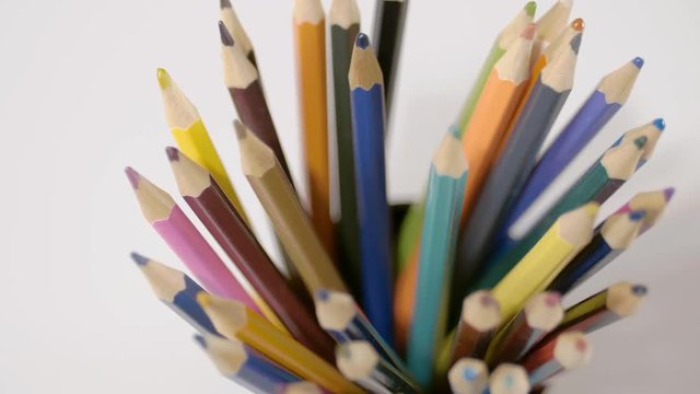 Pencil on a white background. Camera in motion. Pencils are in the glass