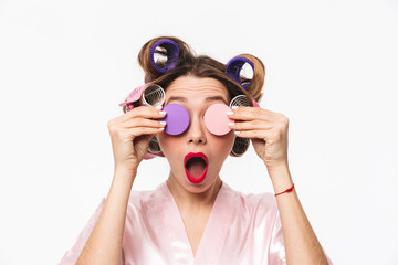 Obraz na płótnie Canvas Cheerful housewife with curlers in hair wearing robe