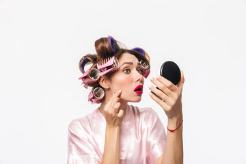 Fototapeta premium Beautiful housewife with curlers in hair wearing robe