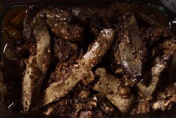 Homemade lamb liver stew in glass bowl on wood