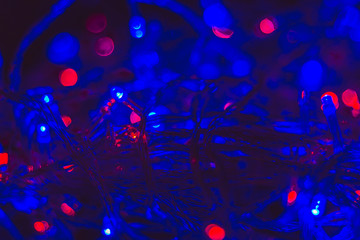 Fototapeta na wymiar Festive elegant abstract background with bokeh lights of blue christmas garlands