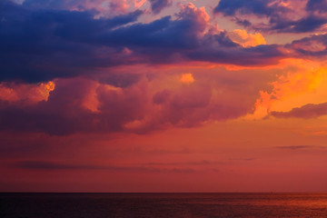 Beautiful colorful sunset on the sea with dramatic clouds