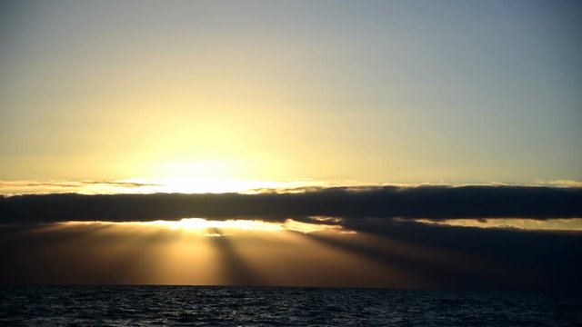 Sun rays through clouds over the sea at sunset. Sardinia, Italy