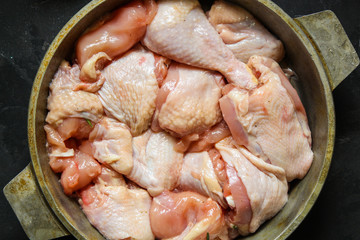 chicken crude pieces - raw meat (dark background). top view. to copy space