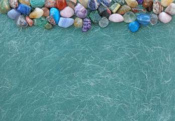 Crystal Healing Therapy Message Board Background - a selection of tumbled gemstones placed across...