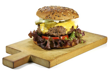 homemade cheeseburger on a wooden board isolated on white background