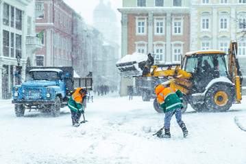 people cleaning city streets after snowstorm