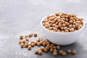 Chickpeas in bowl on grey wooden table