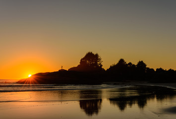 Die Sonne verschwindet hinter den Felsen an einem Strand auf Vancouver Island