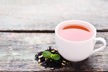 Cup of tea with mint leafs on grey wooden table