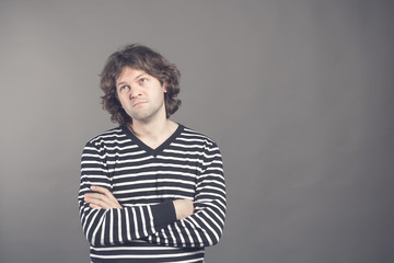 Portrait of caucasian man with bored fed up expression, looks displeased up, being tired to explain his wife where he was at night. Shaggy guy in stripes shirt tired and bored to listen to bullshit