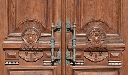 Antique carved wooden door with beautiful bronze handles